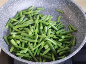 起油锅，加入切碎的蒜炒香，再加入焯水的刀豆翻炒均匀。