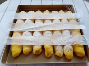 发酵好的面包胚放三张小的纸条，用过滤网撒面粉。