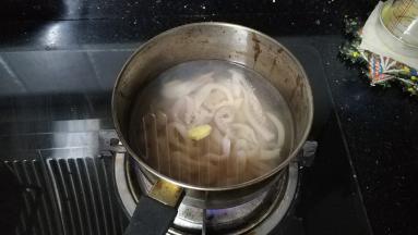 锅里放入水、料酒、姜2片煮开后放入鱿鱼圈焯熟