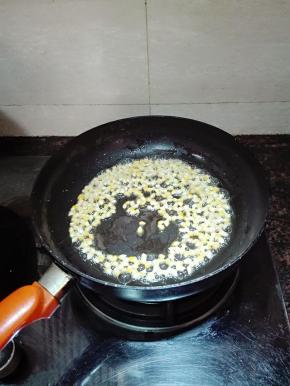 倒入玉米粒。晃动锅子，让每一粒玉米粒都沾上黄油