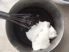 取三分之一打发好的蛋白霜加入到巧克力面糊中，先用蛋抽翻拌均匀