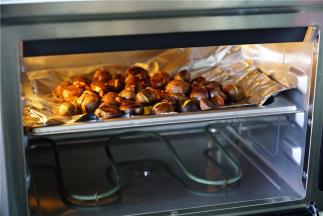 晃至板栗均匀挂上味之后，再放在烤盘里面。160度烤制20分钟就可以，期间要开蒸烤箱拌调好味，这样子板栗受热更均匀。