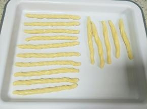 双手拿住面团反方向扭几圈，摆放烤盘上