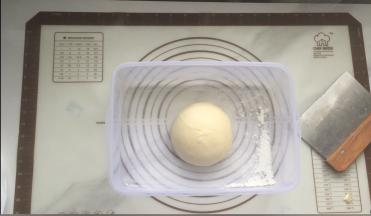 揉好的面团拿出来用手整成团，再放入发酵盒里盖上盖子，放到发酵箱中，发酵温度28度基本发酵60分钟，进行第一次基础发酵