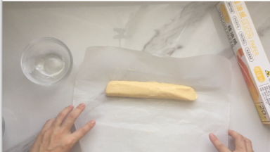 做好的酥皮，拿出来放在油纸上进行整成圆柱形，然后再放入冰箱冷藏30分钟以上