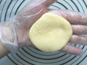 整好面团后，再拿出一个刚刚做好的酥皮，先在手上按扁