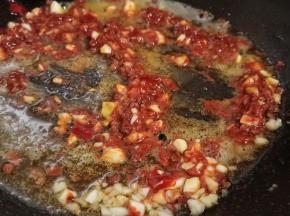 锅里留一点底油，下郫县豆瓣酱、蒜泥、花椒炒香。