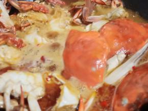 再加螃蟹翻炒出香味，加啤酒一罐、开大火炖入味。