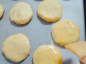 普通的烤盘需要垫上油纸，将饼坯放到烤盘里，摆好，留有空隙。刷上蛋液。