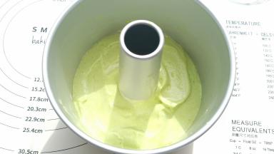 倒入一小部分菠菜糊。震一下模具，再用刮刀刮齐边缘。