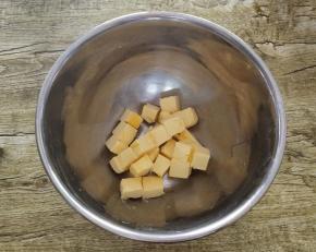 我们先把黄油切成小块放入碗中，自然软化