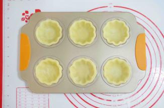 14、将圆形蛋挞酥皮放入模具中。