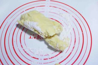 7、将面团倒在揉面垫上，撒少许干粉，揉成一个面团，并且分两半。