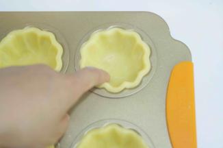 15、用食指将边缘按压出花形，面皮边缘高出模具2mm即可。然后放入冷冻室2小时