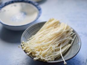 金针菇切掉根部，洗净后，掰成小朵备用；粉丝洗净后，用温水浸泡15分钟