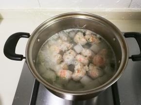 用手挤肉圆放入锅中，盖上盖子烧至肉圆全部漂浮起来