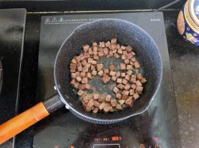 5、倒入牛肉粒翻炒至变色。