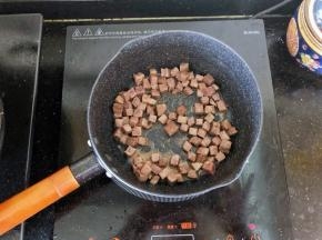 5、倒入牛肉粒翻炒至变色。