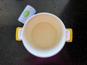 9、九阳鲜米用清水洗净后倒入焖饭煲中，倒入一罐清水。