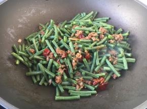 放入豇豆及50g左右的水，翻炒均匀，大火烧开，转小火焖至熟透。
如果是极火烧制虚适当的多放些水。
豇豆需加热10分钟以上，以保证豇豆熟透，有害物质就会分解变成无毒物质了。
但是也要根据豇豆的质地，质地较嫩的豇豆适当缩短烧制时间。