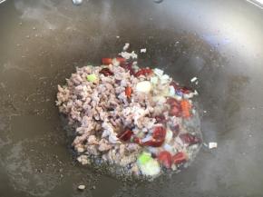 然后将肉末扒在锅的边缘，放入步骤3的作料，炒出香味，再将肉末与佐料混合，翻炒均匀。