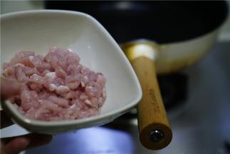 然后我们准备肉丁炒榨辣椒，锅里加适量油，将猪肉丁下锅煸炒出味。