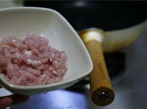 然后我们准备肉丁炒榨辣椒，锅里加适量油，将猪肉丁下锅煸炒出味。