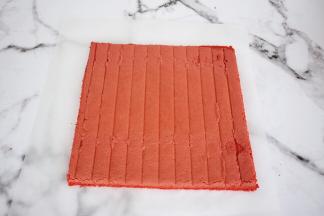 把晾至余温的蛋糕片放在新油纸上，切去四边不规则