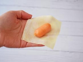 取一张馄饨皮放入一条小香肠