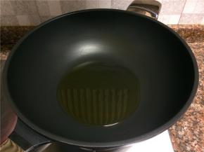 热锅倒油烧至八成热。