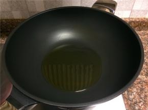 热锅倒油烧至八成热。