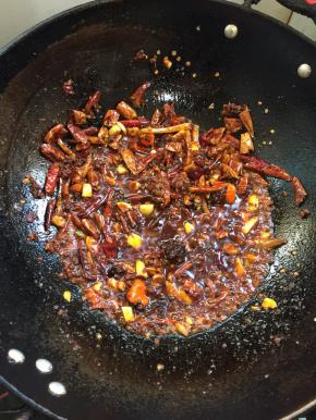 放入郫县豆瓣酱和火锅底料小火煸炒出红油来。