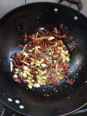 锅里留适量的油，放入蒜瓣，生姜，花椒和干辣椒爆香。