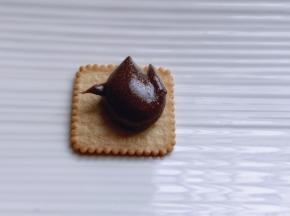 取一块饼干，放上可可牛轧糖！上面再放一块饼干，轻轻按压即可！