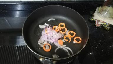 锅里热油放入盐、糖，倒入洋葱丝、红萝卜炒均匀