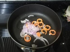 锅里热油放入盐、糖，倒入洋葱丝、红萝卜炒均匀