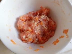 将虾米碎、胡萝卜丁、平菇碎加入猪肉泥，顺一个方向搅匀。