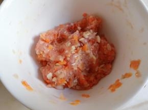 将虾米碎、胡萝卜丁、平菇碎加入猪肉泥，顺一个方向搅匀。
