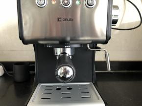 4、将金属漏斗按照咖啡机上的标识，向上放入卡位，然后通过逆时针旋转装入咖啡机中，手柄处于“锁紧”位置，然后打开电源开关。