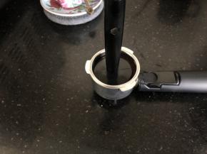 3、将咖啡粉放入金属漏斗内，用量勺的另一端压实。