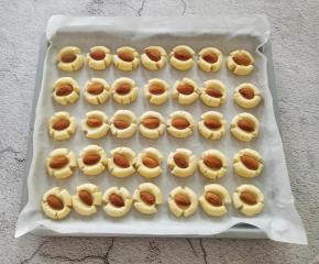 取一个杏仁放在面团上，用大拇指轻轻按压，不要太用力，避免中间太薄，随着拇指的按压会出现自然的断裂