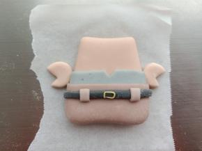 16.黑色面团擀薄片切长条，做出腰带的造型
