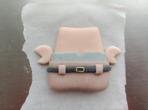 16.黑色面团擀薄片切长条，做出腰带的造型
