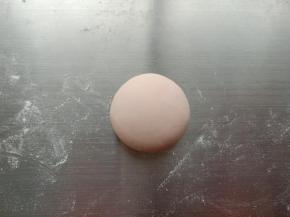21.取20克粉色面团揉圆，稍微压扁一点
