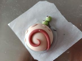 29.粘到小蜗的壳上，再用紫色面团做点缀
