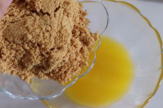 饼干放到袋子中，用擀面杖压成碎末，放入黄油中，混合均匀。