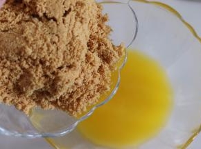 饼干放到袋子中，用擀面杖压成碎末，放入黄油中，混合均匀。