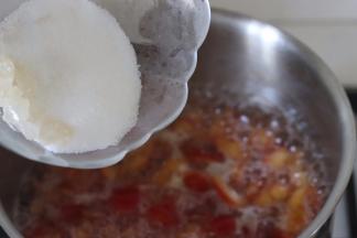 水沸腾后，继续小火加热水分变少后，加入剩余的冰糖和白砂糖。