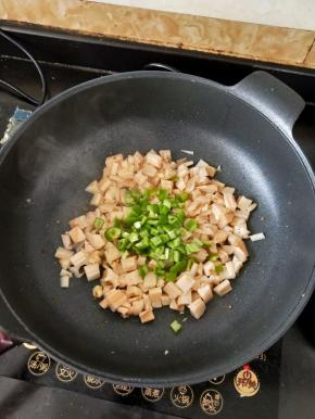 接着倒入尖椒块，翻炒片刻。