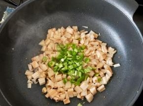 接着倒入尖椒块，翻炒片刻。